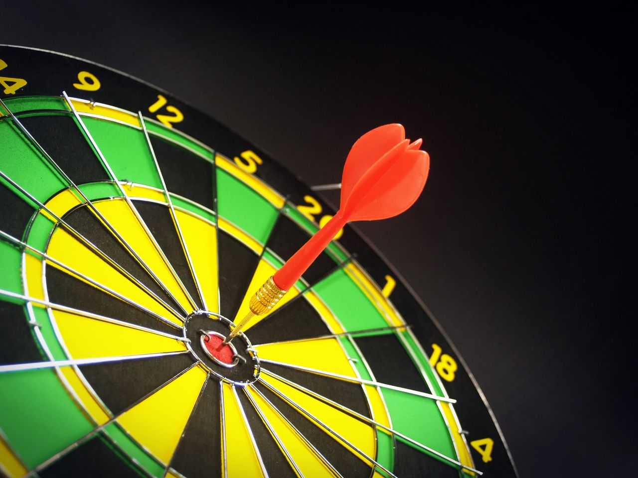 Crafting Captivating Headlines: Your awesome post title goes here Close-up of a dart successfully hitting the bullseye on a bright dartboard, signifying victory.